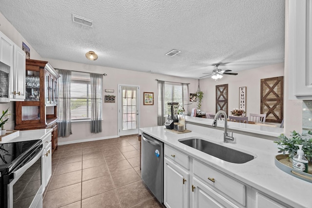 kitchen with a sink, stainless steel appliances, light countertops, white cabinets, and visible vents