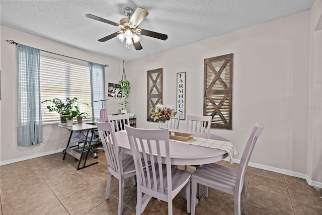 dining room featuring light tile patterned flooring, a textured ceiling, a ceiling fan, and baseboards