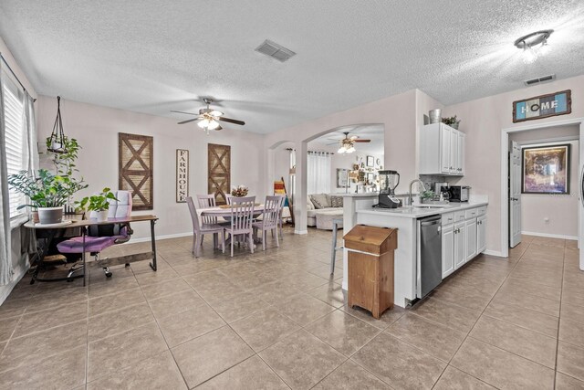 kitchen with light countertops, visible vents, a textured ceiling, and ceiling fan