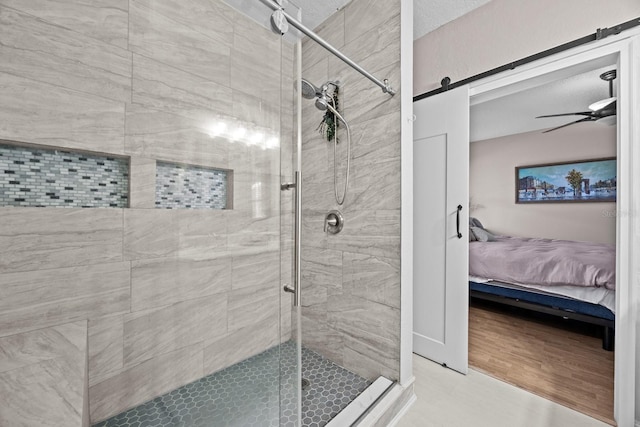 full bathroom with connected bathroom, a ceiling fan, and a stall shower