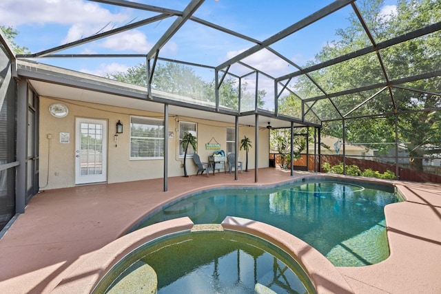 view of pool featuring a patio area, ceiling fan, glass enclosure, and a pool with connected hot tub