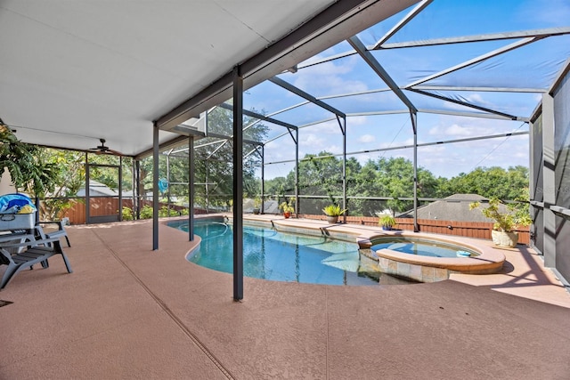 view of pool featuring a lanai, a fenced backyard, a pool with connected hot tub, and a patio