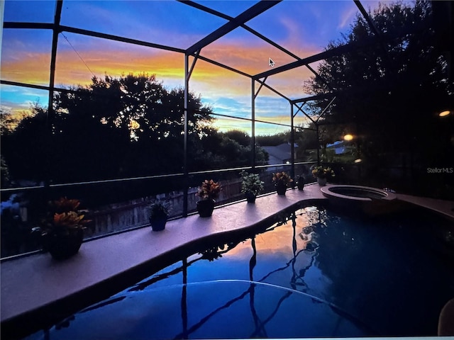 outdoor pool with a lanai, a patio, and an in ground hot tub