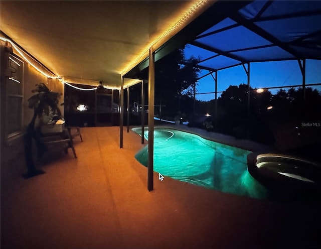 outdoor pool featuring glass enclosure and a patio