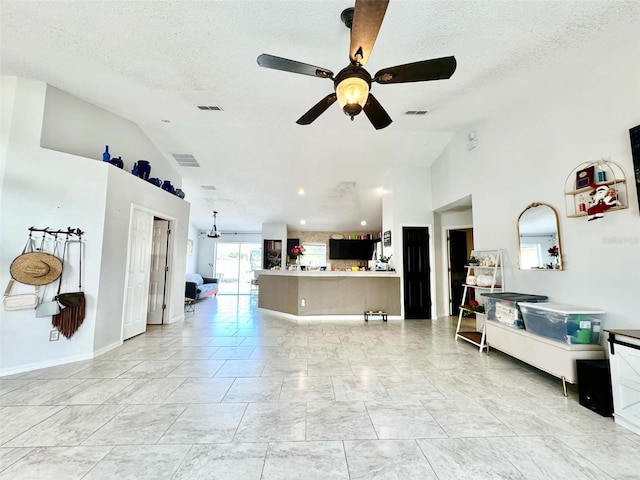 living room with ceiling fan, high vaulted ceiling, and a textured ceiling