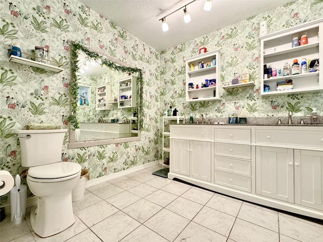 bathroom with a tub, tile patterned flooring, toilet, track lighting, and a textured ceiling