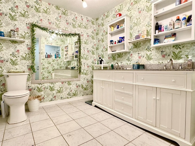 bathroom with tile patterned floors, vanity, toilet, and a textured ceiling