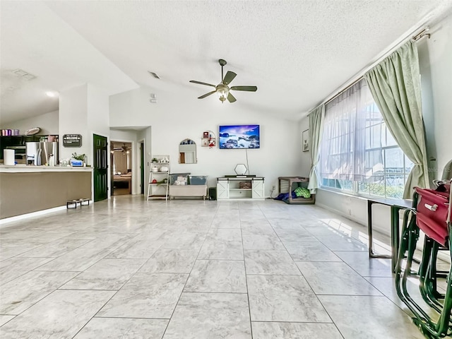 living room with vaulted ceiling, a textured ceiling, and ceiling fan