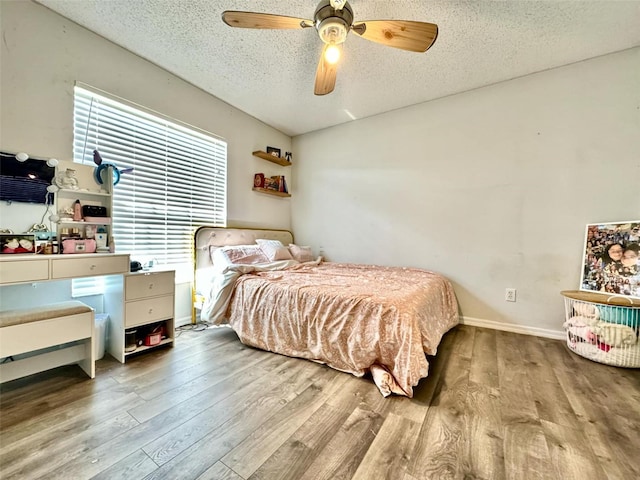 bedroom with ceiling fan, a textured ceiling, and light hardwood / wood-style flooring