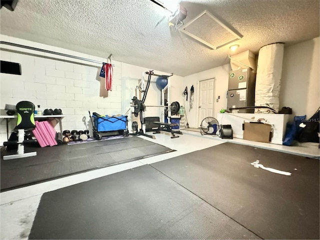 workout room with heating unit and a textured ceiling