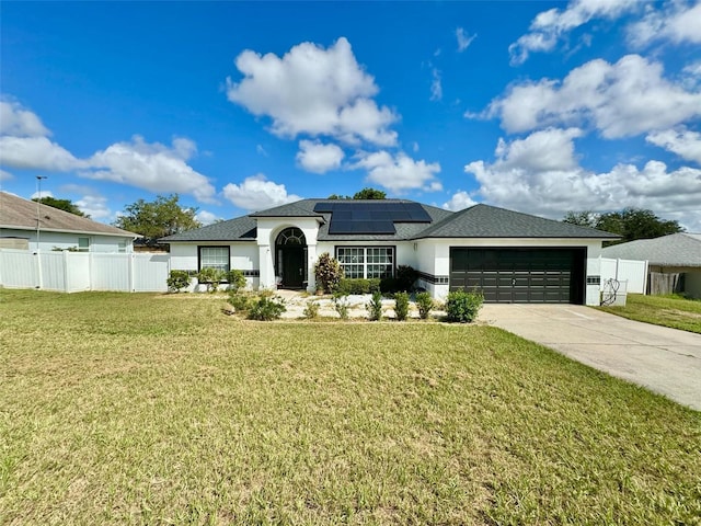 view of front of property featuring a garage, a front yard, and solar panels