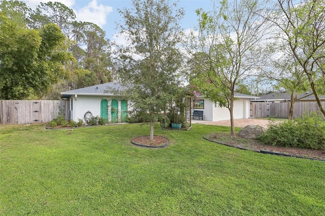 exterior space with an attached garage, fence, driveway, a lawn, and stucco siding