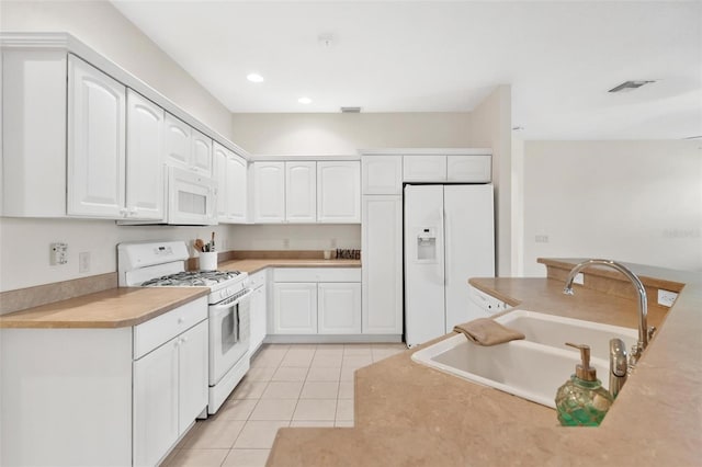 kitchen featuring sink, white appliances, white cabinets, and light tile patterned flooring