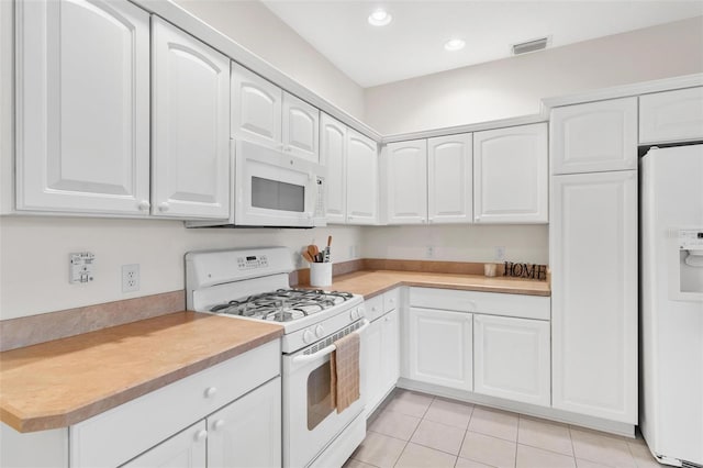 kitchen featuring white appliances, white cabinets, and light tile patterned flooring