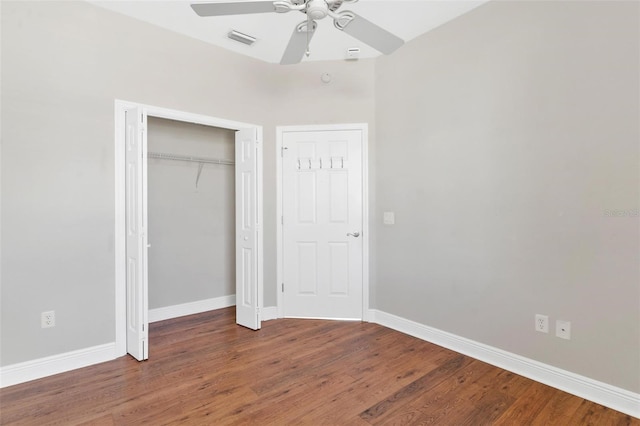 unfurnished bedroom with dark wood-type flooring, ceiling fan, and a closet