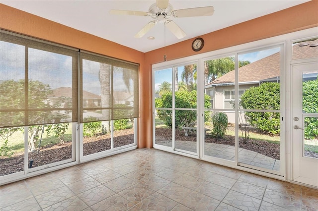 unfurnished sunroom featuring ceiling fan