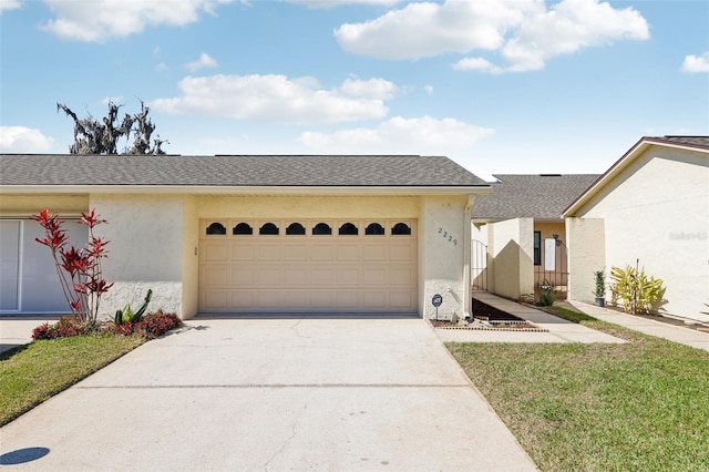 view of front of house featuring driveway, an attached garage, a shingled roof, and stucco siding