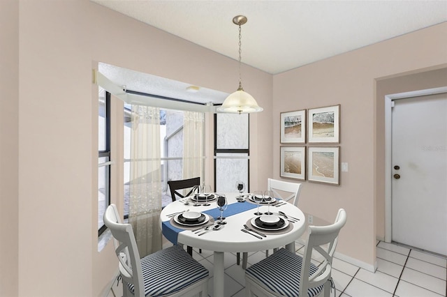 dining space featuring light tile patterned floors and baseboards