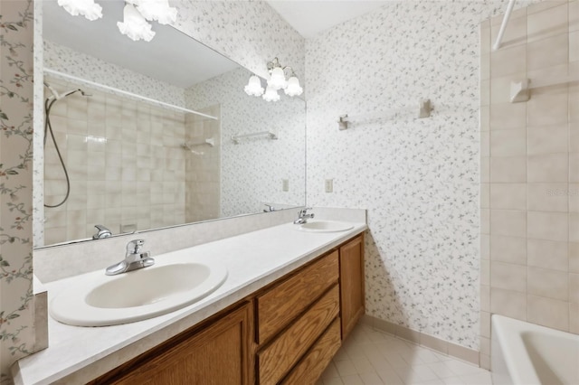 full bath with wallpapered walls, a sink, and tiled shower