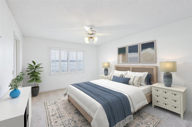 bedroom featuring a ceiling fan, light carpet, and a textured ceiling