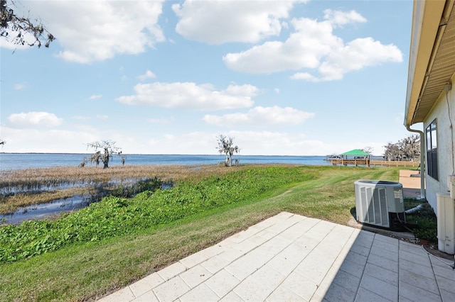 view of patio with central air condition unit and a water view