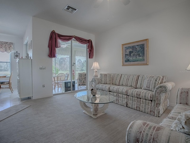 carpeted living room with ceiling fan