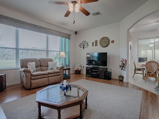 living room with ceiling fan, wood-type flooring, and plenty of natural light