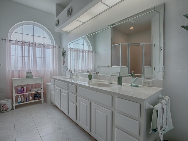 bathroom featuring a shower with door, vanity, and tile patterned floors