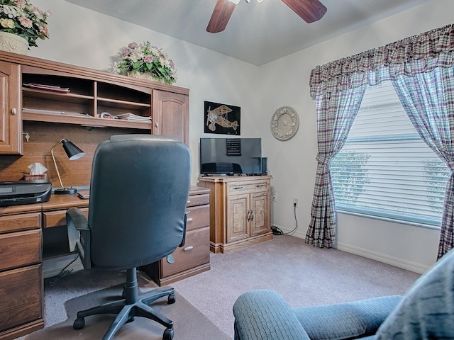 carpeted home office with plenty of natural light and ceiling fan