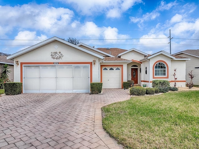 single story home featuring a garage and a front lawn