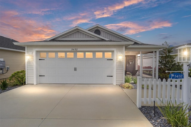 ranch-style home with a garage, driveway, board and batten siding, and fence