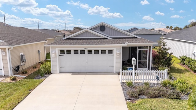 single story home with a garage, a shingled roof, fence, driveway, and board and batten siding