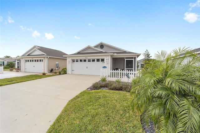 view of front of house with a front yard, concrete driveway, and an attached garage