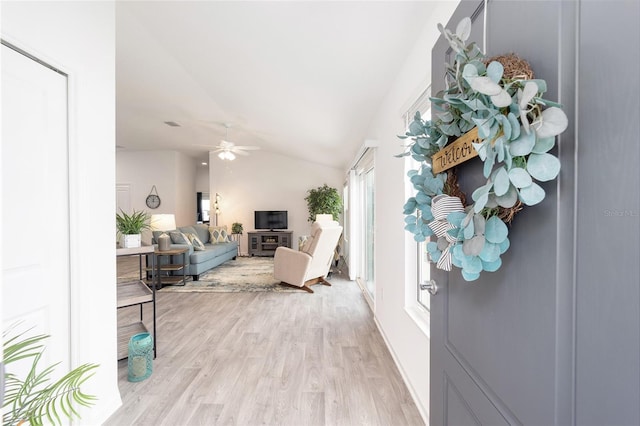 living room with vaulted ceiling, ceiling fan, and light wood finished floors