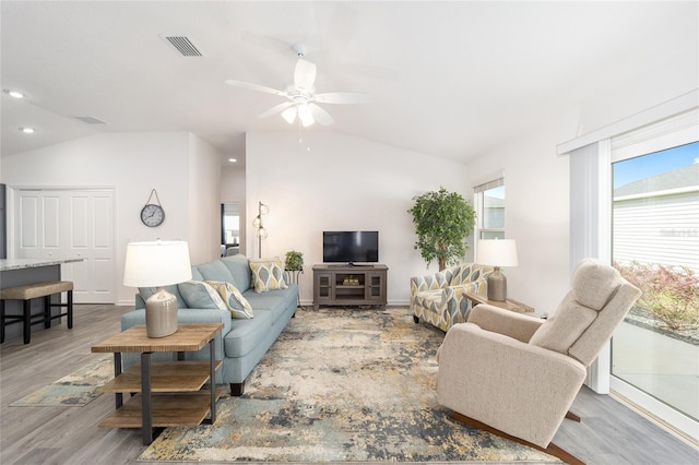 living room featuring lofted ceiling, recessed lighting, visible vents, light wood-style flooring, and a ceiling fan