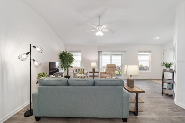 living room with lofted ceiling, ceiling fan, wood finished floors, and baseboards