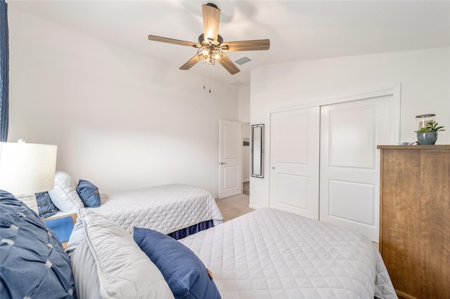 bedroom featuring ceiling fan, lofted ceiling, light carpet, visible vents, and a closet