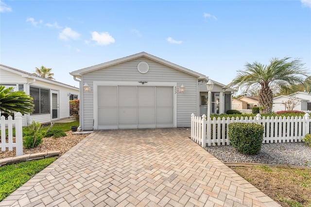 exterior space featuring decorative driveway and fence