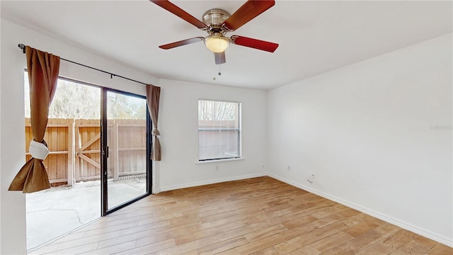 empty room featuring a ceiling fan, light wood-type flooring, and baseboards