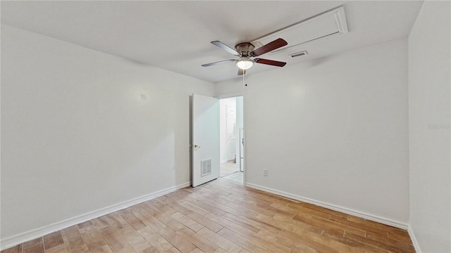 empty room featuring light wood finished floors, baseboards, and visible vents