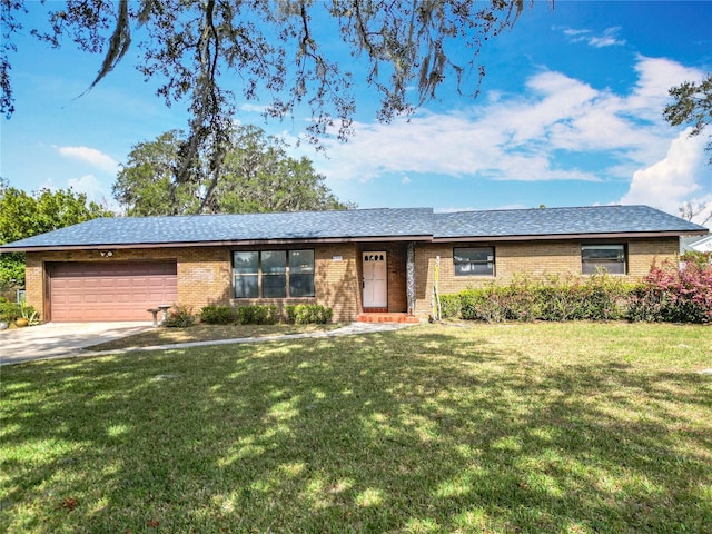 ranch-style home with a garage and a front lawn