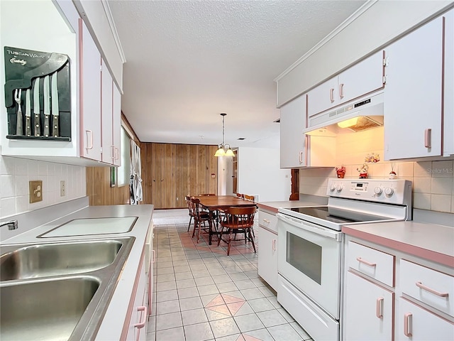 kitchen with sink, white range with electric stovetop, tasteful backsplash, white cabinets, and decorative light fixtures