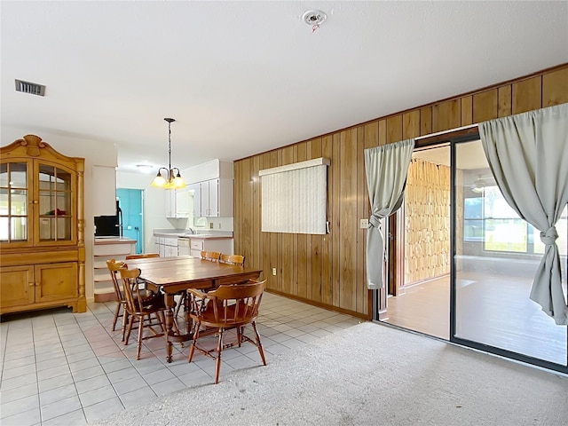 carpeted dining area featuring wooden walls