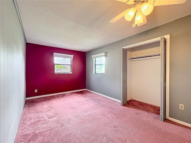 unfurnished bedroom featuring ceiling fan, a closet, carpet, and a textured ceiling