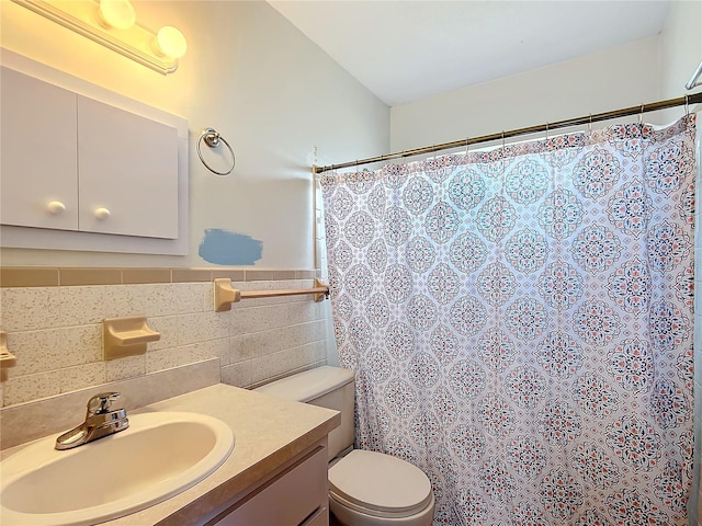 bathroom with vanity, tile walls, and toilet