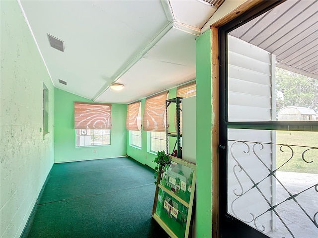 carpeted spare room featuring vaulted ceiling