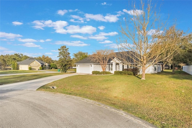 ranch-style house featuring a garage and a front lawn