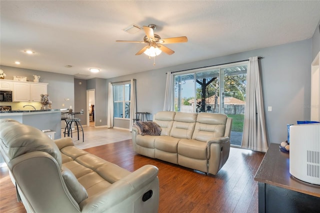 living room with wood-type flooring and ceiling fan