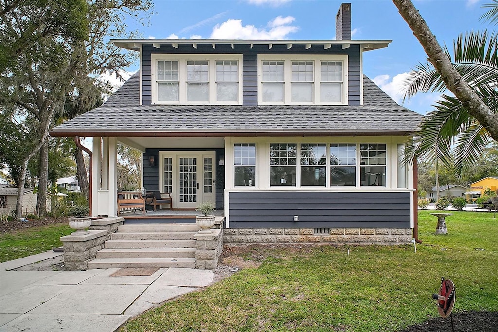 view of front of home with a front lawn and french doors