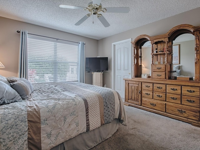 carpeted bedroom with a textured ceiling and a ceiling fan